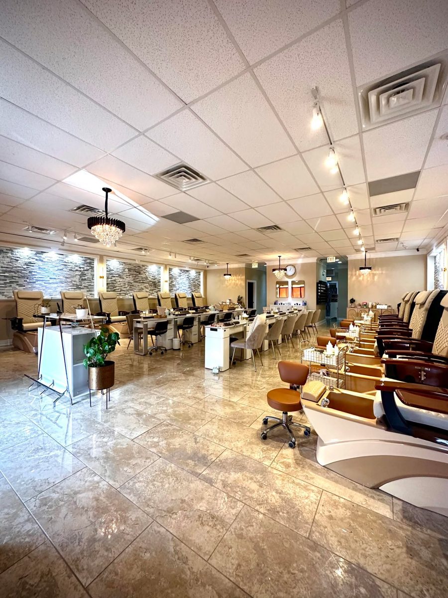 Wide view of the Glow Nails salon interior with rows of pedicure chairs and manicure tables