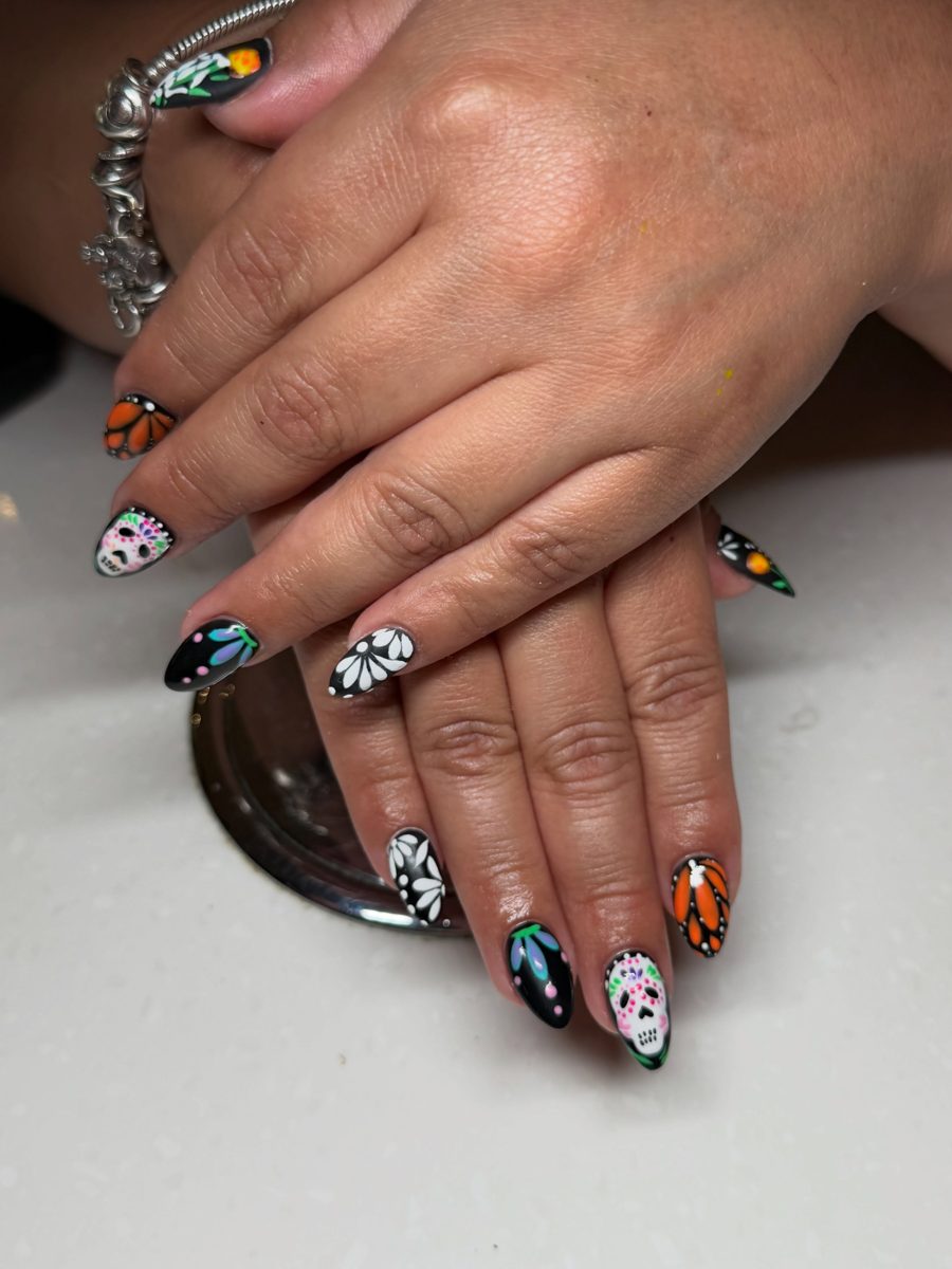 Hand-painted sugar skull and butterfly nail art on black almond nails